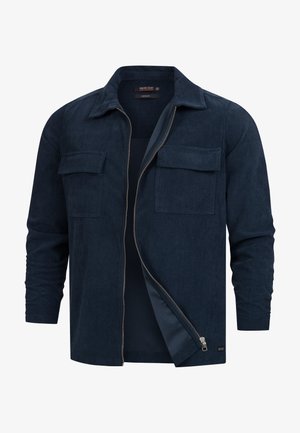 Veste en velours côtelé navy avec un col, deux poches avant et une fermeture éclair à l'avant. Texture côtelée et manches mi-longues.