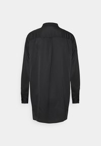 Maglietta nera a maniche lunghe, con texture in satin liscio, colletto con bottoni, orlo curvo, con una schiena semplice senza motivi o dettagli aggiuntivi.