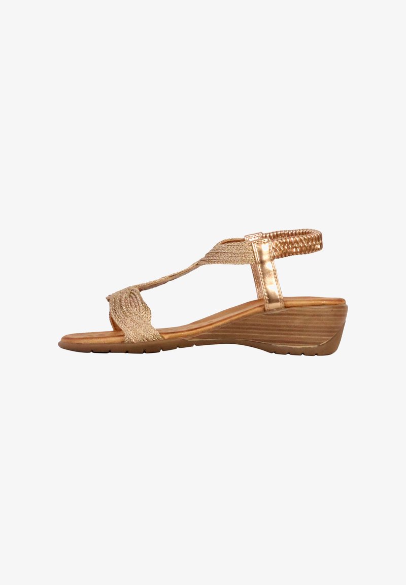 Sandale compensée avec une sangle dorée texturée, un design avant tressé et un talon en bois courbé. Semelle intérieure lisse et semelle en caoutchouc pour une meilleure adhérence.