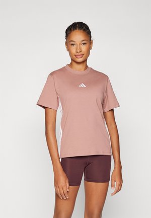 Tricou sportiv cu mânecă scurtă, de culoare roz deschis, cu gât rotund și dungi albe pe laterale. Prezintă un logo mic al mărcii pe piept.