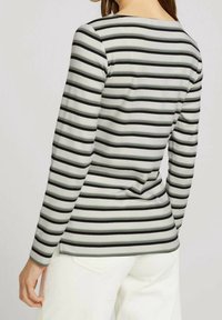 Långärmad skjorta i ljusgrått med svarta horisontella ränder, med rund halsringning och en figurnära design. Mjuk bomullsblandning.