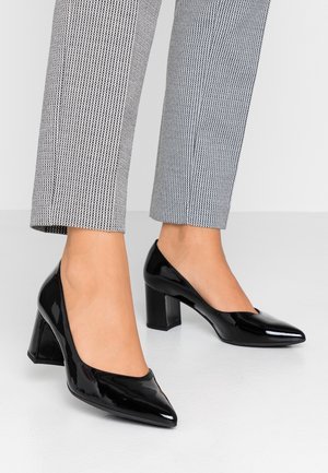 Schwarze Lackleder-High-Heels mit spitzen Zehen und rechteckigen Absätzen, kombiniert mit karierten Hosen, die ein elegantes Design und eine glänzende Textur zeigen.
