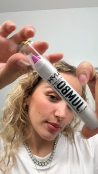 Pennarello bianco e argento con punta viola, dotato di un corpo cilindrico trasparente e di lettering nero audace sull'etichetta.