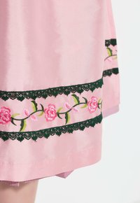 Vaate made of pink satin, jossa on kukkakirjontakuvio vihreillä yksityiskohdilla ja mustalla pitsireunalla helman ympärillä. Sujuva tekstuuri kerroksellisella yksityiskohdalla.