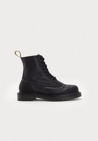 Botine negre cu un capac superior din piele texturată, vârf din material cauciucat și talpă groasă. Prezintă șireturi rotunde și o bandă galbenă de prindere în spate.