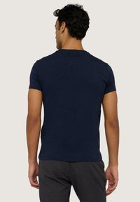 Námořnický modrý tričko s krátkým rukávem vyrobené z bavlněné tkaniny, s jednoduchým kulatým výstřihem a standardním střihem. Hladký povrch bez viditelných vzorů.