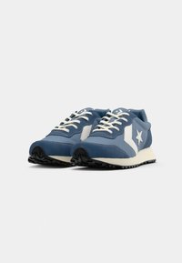 Blue athletic shoes with white accents, synthetic material, round toe, textured sole, and contrasting star logo on the side.