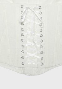 Corset blanc avec laçage en ruban satin à travers des œillets métalliques, montrant une fermeture avant et des détails de couture structurée.