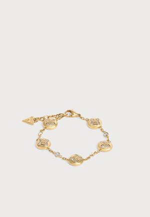 Bracelet ton or avec six maillons ronds ornés et petites pierres transparentes, avec un fermoir mousqueton et un pendentif triangulaire de la marque.