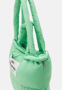 Borsa tote imbottita in verde menta vivace, con tessuto morbido, manici doppi ad anello, etichetta rettangolare e accento a righe nere e bianche.