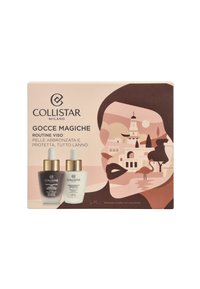 Collistar Gocce Magiche gift set with two dropper bottles: one dark and one light, both with gold accents, set against a stylized background.