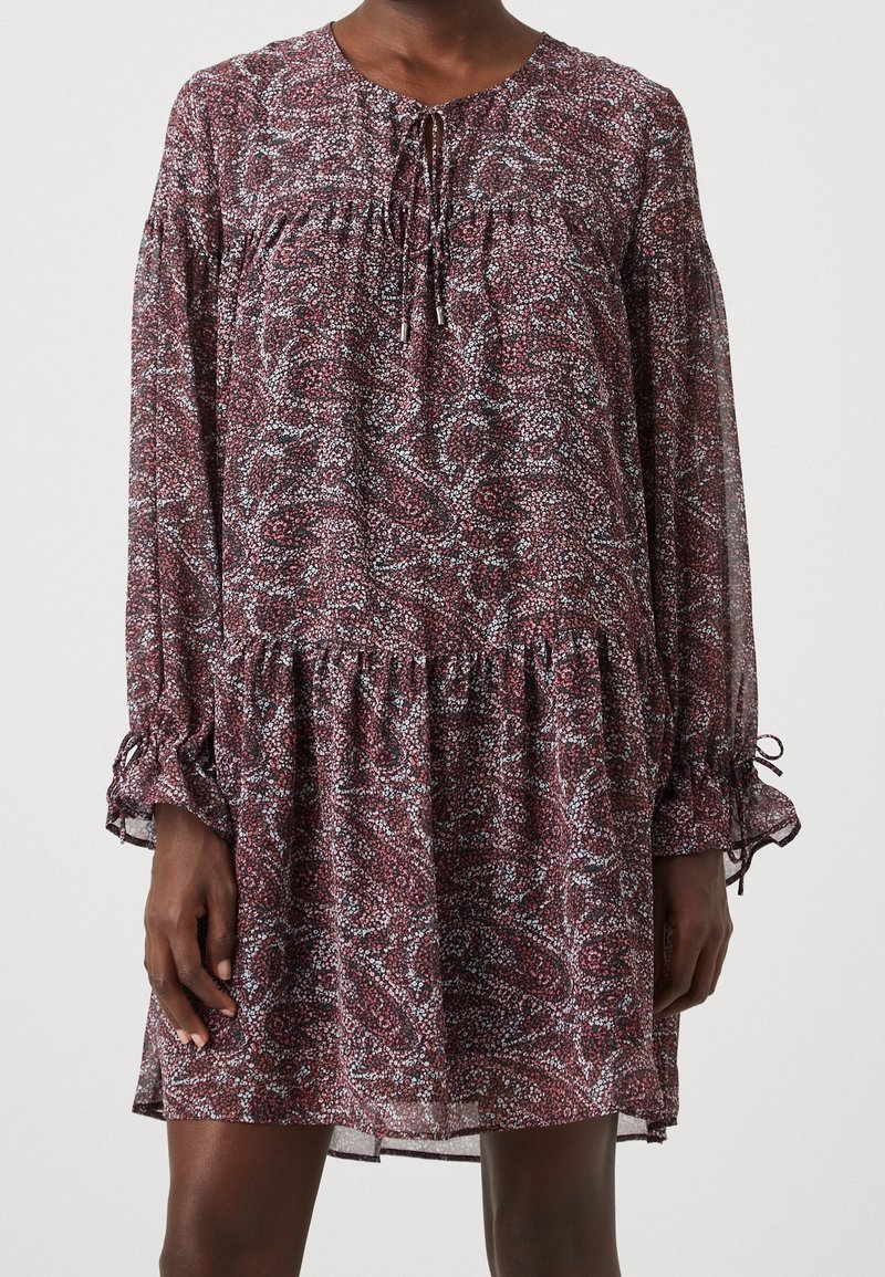 Robe à imprimé floral couleur bordeaux, avec manches longues, encolure froncée avec un lien, et ourlet à volants. Tissu léger et fluide.