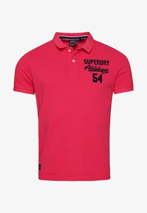 Rotes kurzärmeliges Polohemd mit geknöpftem Kragen und schwarzem Schriftzug "Superdry Athlétique 54" auf der oberen linken Brust.