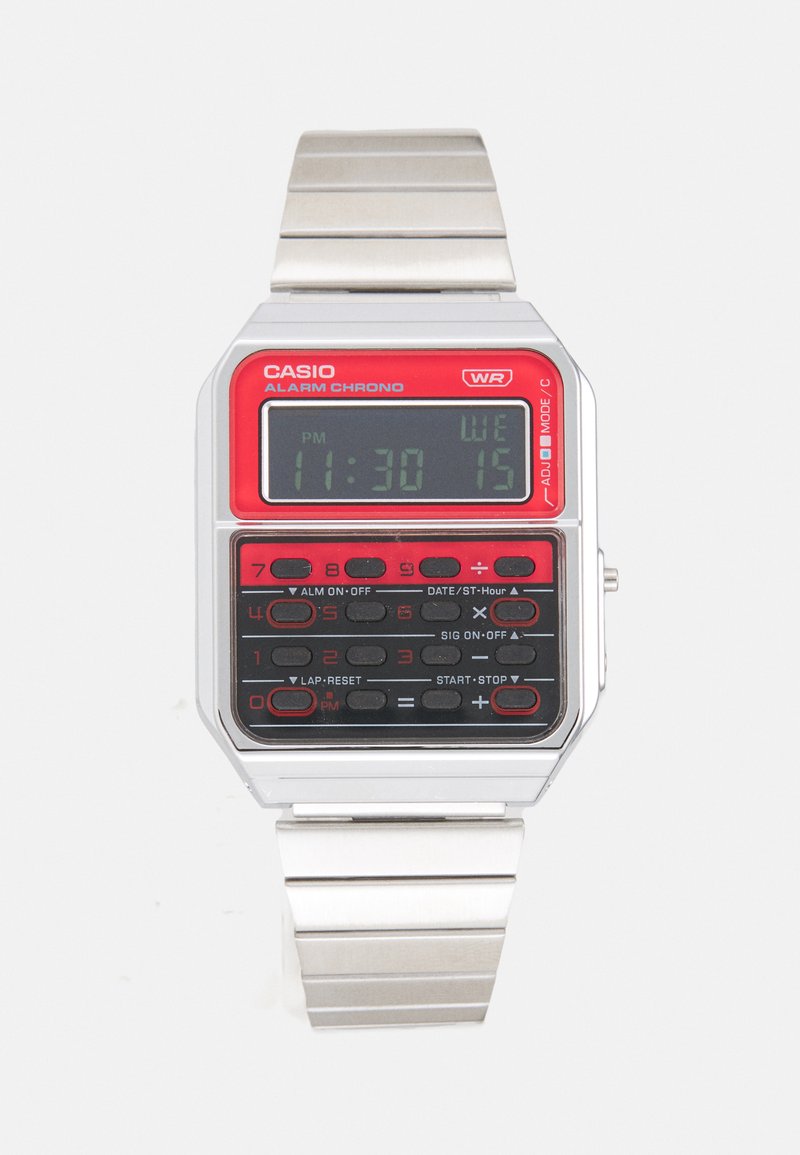 Relógio digital Casio com pulseira metálica prateada, mostrador retangular em vermelho e preto, e vários botões para funções como alarme e cronômetro.