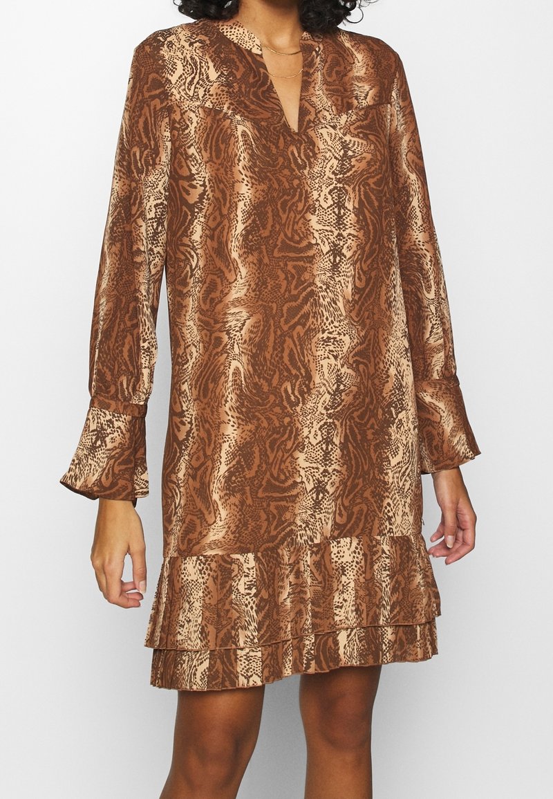 Braun-schlangenbedrucktes Kleid mit langen Ärmeln, V-Ausschnitt und gerafftem Saum. Hergestellt aus glattem Stoff; zeigt eine Mischung aus hellen und dunklen Mustern.