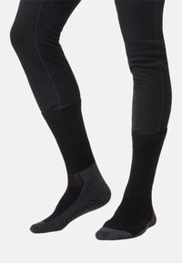 Zwarte sokken met geribbelde textuur, voorzien van een donkergrijze hiel- en teenafdeling. Versterkte panelen zorgen voor duurzaamheid en ondersteuning.