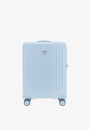 Niebieska twarda walizka z pionowymi żebrami, srebrną tabliczką z logo oraz czterema wielokierunkowymi kółkami. Posiada górny uchwyt ułatwiający podnoszenie.