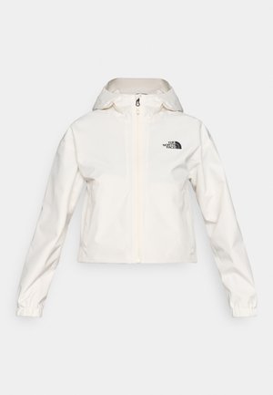 Chaqueta blanca recortada con cremallera en el frente, capucha con cordón y logo negro en el pecho. El material parece liso y resistente al agua.