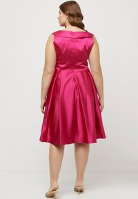 Satinrosa klänning med en figursydd överdel, bred krage och utsvängd kjol. Baksidan har en dragkedja och veck för extra textur.