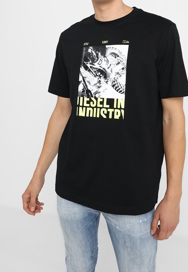 Black cotton t-shirt featuring a graphic print of industrial imagery with yellow text reading “DIESEL IN INDUSTRY.” Short sleeves and a relaxed fit.