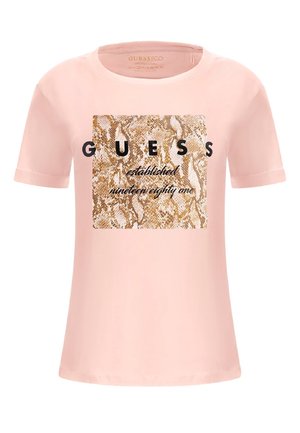 Jasnoróżowa koszulka z krótkim rękawem z kwadratem w wzór skórę węża i nadrukiem "GUESS established nineteen eighty one" z przodu.