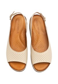 Beżowe sandały na otwartym palcu z perforowanym wzorem, skórzaną cholewką, regulowanym paskiem wokół kostki i miękką wkładką dla komfortu.