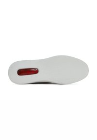Witte sneaker zool met een getextureerde grip, met een rode doorzichtige accent en een glad oppervlak. Gegraveerd patroon over de onderkant.