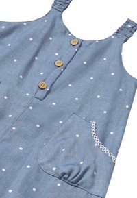 Vestido azul con puntos blancos, cierre de botones, tirantes ajustables y un bolsillo fruncido con borde de encaje. Hecho de tela ligera.