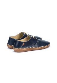 Zapatos de cuero navy con punta redondeada, cordones crema y detalles tejidos en beige alrededor de la suela. Forro interior suave y suela exterior de goma flexible.