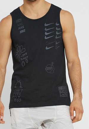 Mann trägt ein schwarzes ärmelloses Hemd mit mehreren Nike-Logos und handschriftlich gestalteten Grafiken, darunter eine Blume, ein Stoppschild und Phrasen.