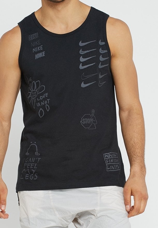 Homme portant un débardeur noir avec plusieurs logos Nike et des graphismes de style manuscrit, comprenant une fleur, un panneau stop et des phrases.