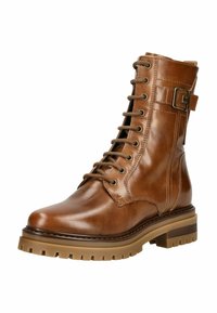 Botte chelsea en cuir marron avec un bout rond, un laçage à l'avant et des détails de sangle. Présente une semelle épaisse et texturée pour une meilleure adhérence.