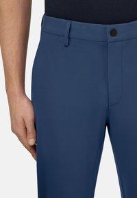 Marineblaue Hose mit glatter Textur, ausgestattet mit einem Knopfverschluss und flacher Vorderseite. Entworfen mit Seiten- taschen und maßgeschneiderter Passform.