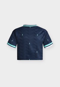 Chemise bleu marine à manches courtes avec poignets et col rayés bleu clair et blanc, présentant des motifs chevrons subtils et petits diamants dans le dos.