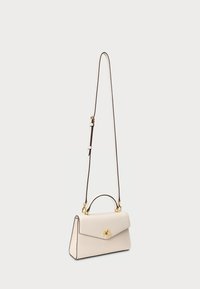 Κρεμ δερμάτινη τσάντα χεριού με δομημένο σχέδιο, χρυσές αναφορές, αποσπώμενος ιμάντας ώμου και λαβή στην κορυφή. Διαθέτει κλείσιμο με καπάκι.