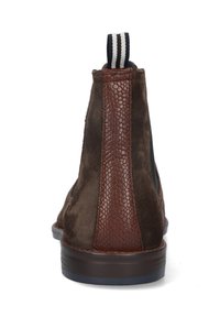 Bottines en daim marron avec des accents en cuir texturé marron, panneaux latéraux élastiques et une languette rayée à l'arrière. Semelle plate.