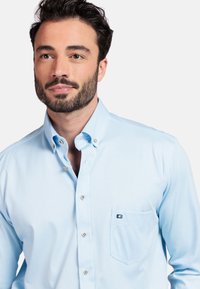 Lichtblauwe overhemdd met knopen, gemaakt van een katoenmix, met een klein zakje met een logo, een klassieke kraag en knopen.