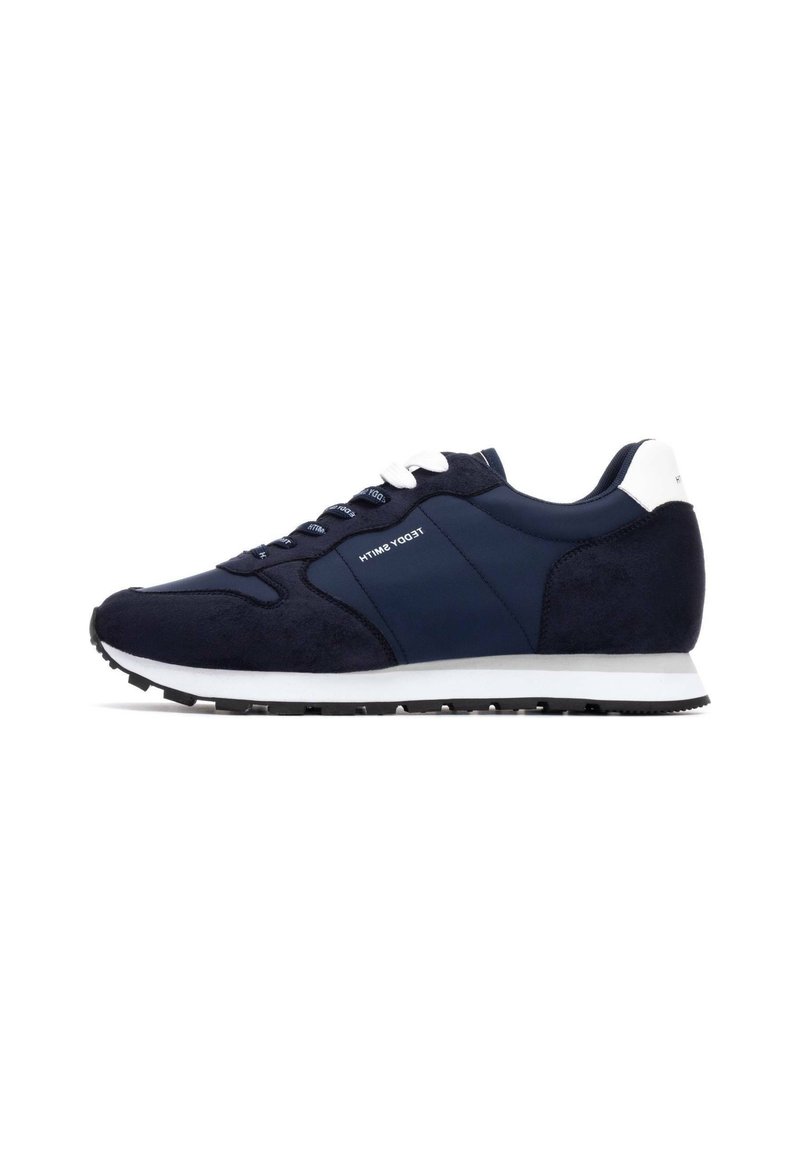 Marineblauwe sport sneaker van suede en gladde stof, met witte accenten op de hiel en veters, en een zwarte rubberen zool.