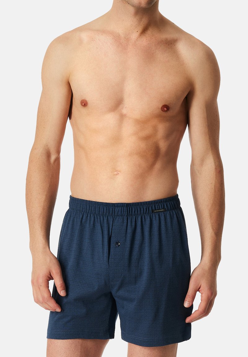 Boxer shorts bleu marine en tissu doux, dotés d'une taille élastique et d'un détail bouton à l'avant avec un motif texturé subtil.