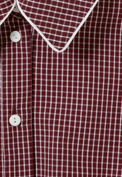 Camisa a cuadros burdeos con patrón de rejilla blanca, cuello clásico, ribete blanco y dos botones blancos en el frente.