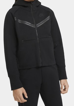 Felpa nera Nike con zip presenta un design aderente, due tasche anteriori, un cappuccio e sottili strisce riflettenti sulla parte anteriore.