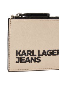 Beige textured leather cardholder with black zipper and embossed "KARL LAGERFELD JEANS" logo on the front, featuring a compact rectangular shape.