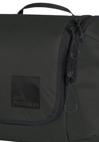 Bolso mensajero de color gris oscuro con superficie texturizada, que presenta un parche de logo negro, cierre de cremallera y un asa en la parte superior para facilitar su transporte.