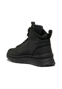 Chaussures montantes noires avec une surface en cuir lisse, un embout arrondi et une semelle en caoutchouc texturée. Présente des œillets en métal et un col rembourré.