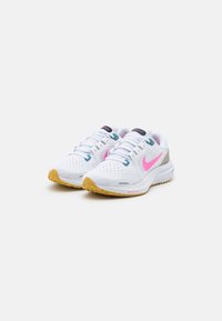 Scarpe sportive bianche con dettagli rosa, tomaia in rete, suola imbottita e suola in gomma. Presentano dettagli blu e neri sui lacci.