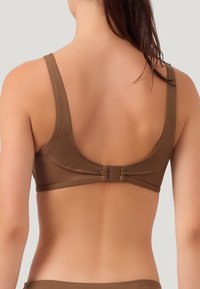 Reggiseno wireless marrone con spalline larghe, tessuto liscio e design a schiena bassa con piccolo gancio regolabile.