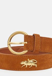 Tan suède riem met een gouden ronde gesp en een gouden kattenontwerp accent. Gladde textuur met een zachte afwerking, met een gestikte rand.