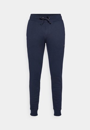 Pantalons de survêtement bleu marine en tissu doux, dotés d'une taille élastique avec cordon de serrage, et jambes fuselées avec des bords côtelés.
