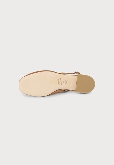 Sole of a tan leather sandal with a square toe and low heel, showing brand text and logo on the light-colored sole.