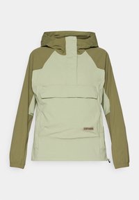 Lys grønn og olivengrønn anorakkjakke med hette, med en frontlomme, elastiske mansjetter og et merket patch. Materialet virker glatt og lett.